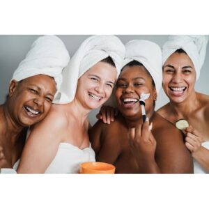 Multicultural group of midlife women laughing and enjoying spa day together.