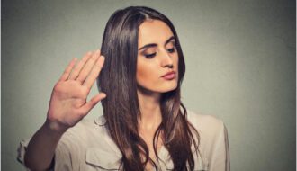 Woman with her hand up to say "stop talking."