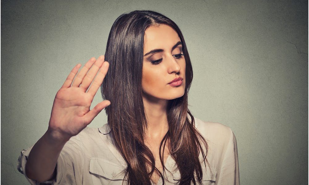 Woman with her hand up to say "stop talking."